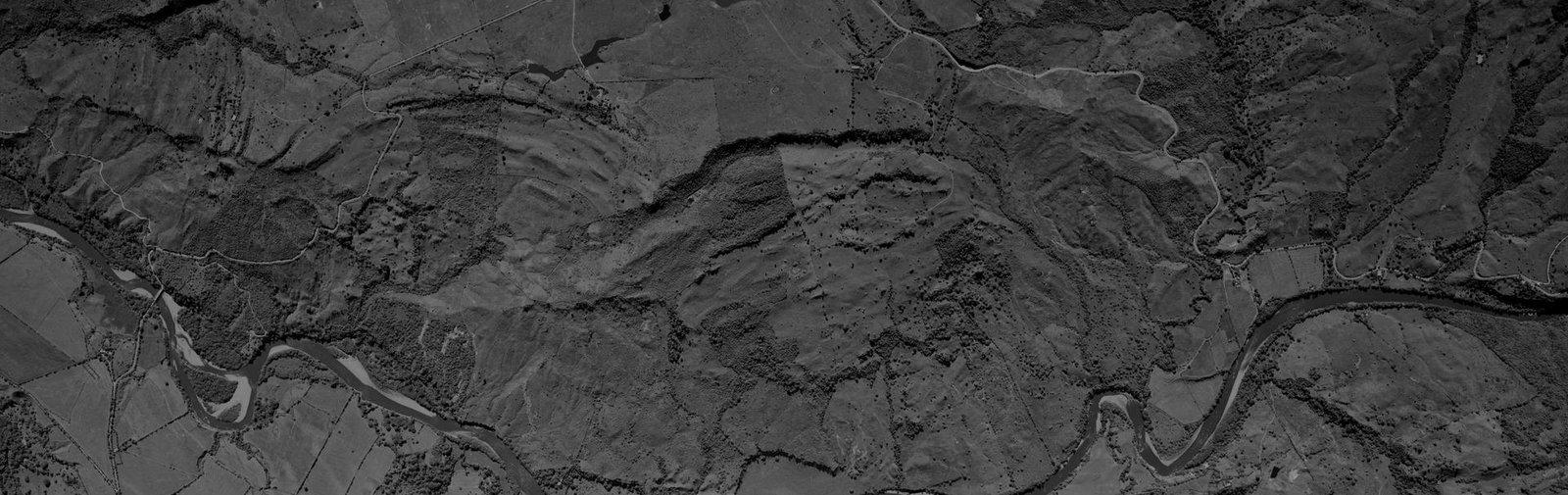 Fotografía aérea histórica de un valle con evidencias de procesos de ladera